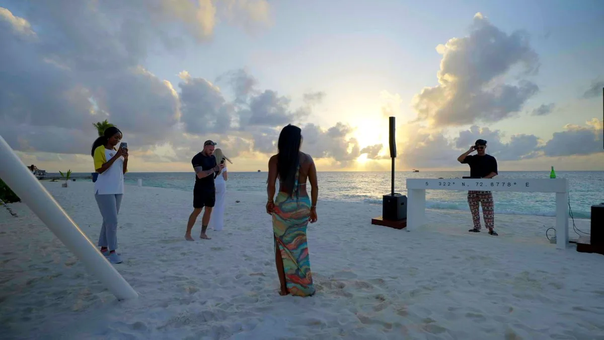 Sunset on the beach, guests and the coordinates marker