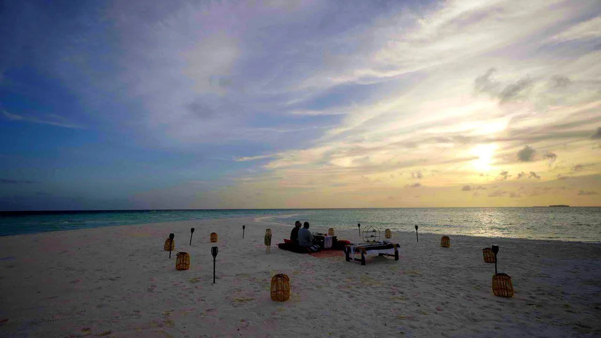 Lanterns set for dinner on an empty beach