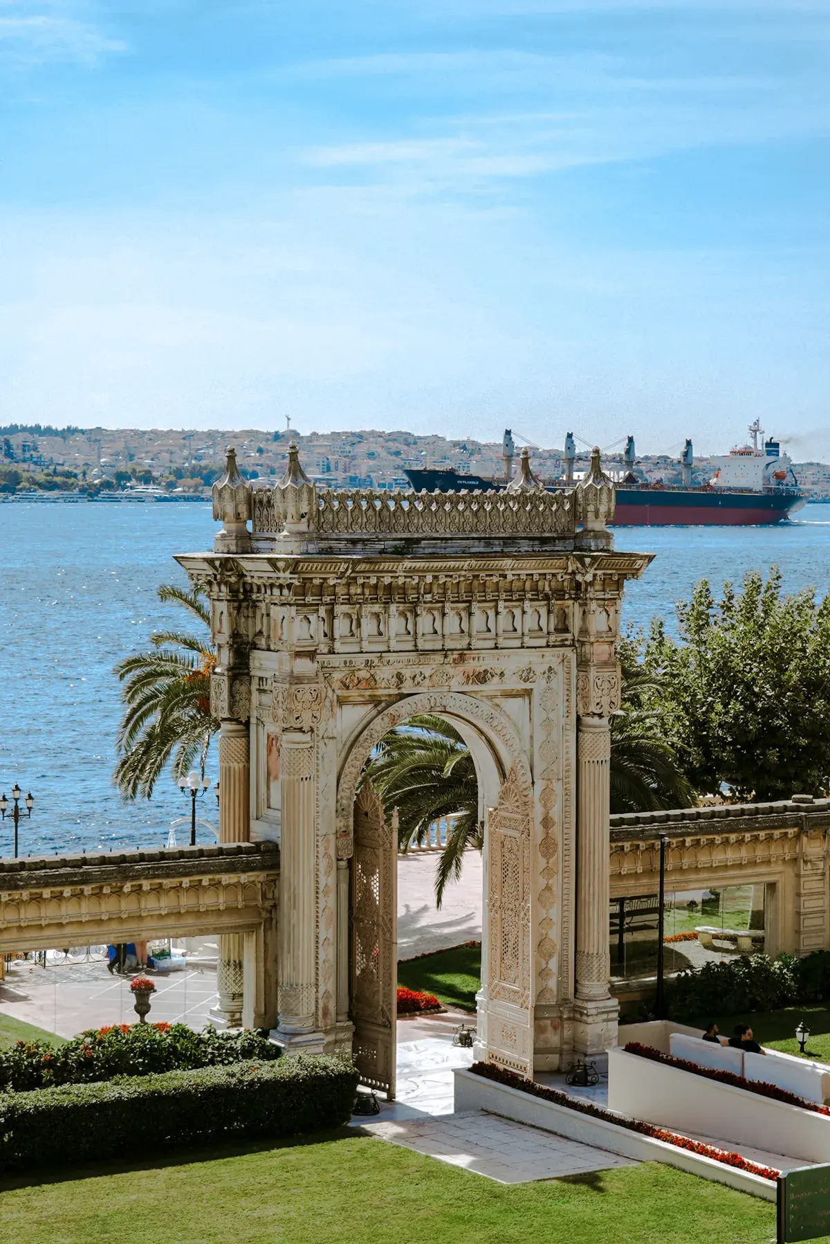The Bosphorus shipping lane, framed through the palace gate at Dolmabahçe