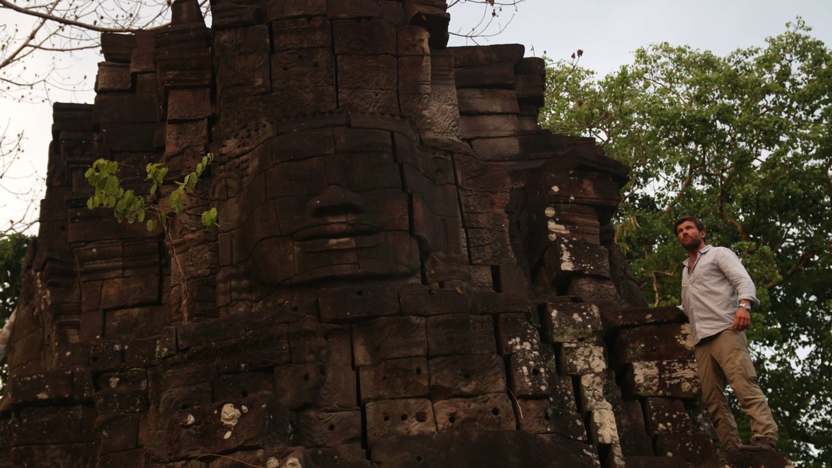 Jonathan Legg climbing a Bayon-style face tower, Cambodia